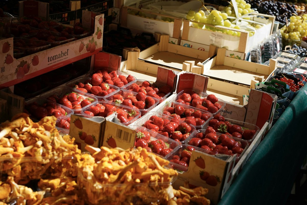 Étal de marché parisien : barquettes de fraises et cagette de girolles